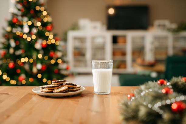 Cookies and Milk on the table in front of a Christmas tree. 